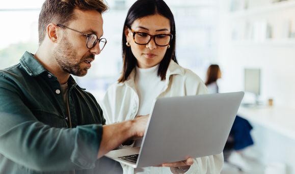 Stock two people viewing laptop. 